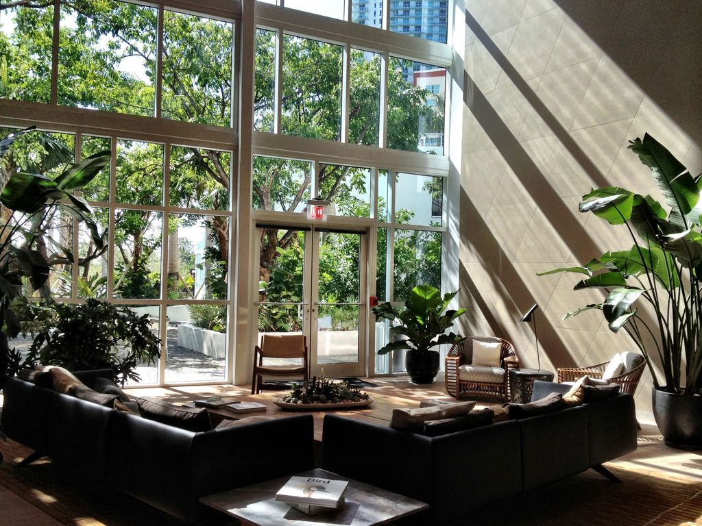 A bright living room with floor-to-ceiling windows overlooking trees